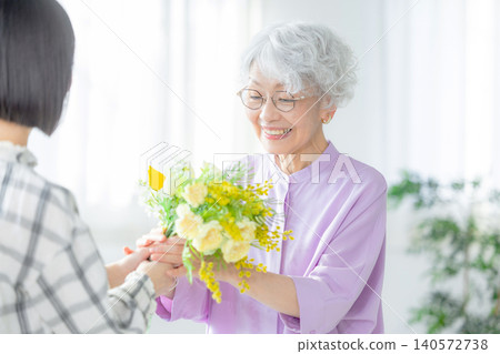 A grandchild gives a bouquet of flowers on Respect for the Aged Day A grandchild gives a bouquet of flowers on Respect for the Aged Day 140572738