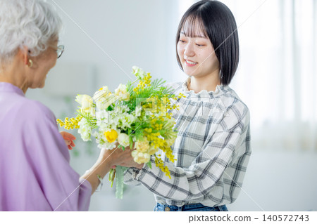 A grandchild gives a bouquet of flowers on Respect for the Aged Day A grandchild gives a bouquet of flowers on Respect for the Aged Day 140572743