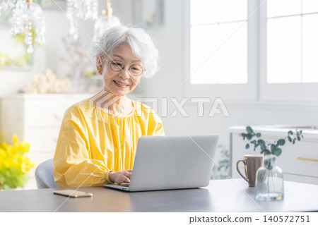 A senior woman operating a computer A senior woman operating a computer 140572751