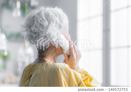 一位老婦人正在用座機打電話。 140572755