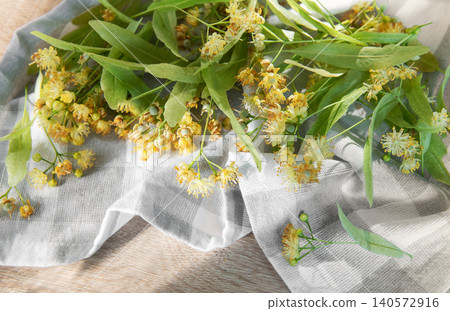 Linden flowers and leaves on a textile napkin 140572916