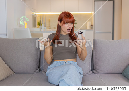 Young woman with smartphone sees bad news sighs after game loss failed bet sad gaze upset reaction 140572965