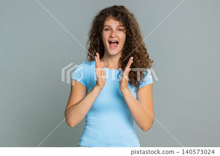 Young woman joyfully laughing clapping hands excited happiness cheerful positive emotional reaction Young woman joyfully laughing clapping hands excited happiness cheerful positive emotional reaction 140573024