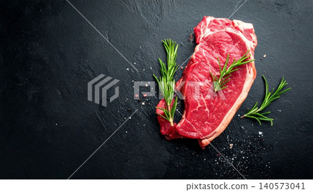 Steak with rosemary on a black background. Top view 140573041