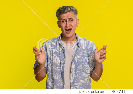 Adult man crossing fingers in hope then showing disappointed face after losing or failed expectation Adult man crossing fingers in hope then showing disappointed face after losing or failed expectation 140573161