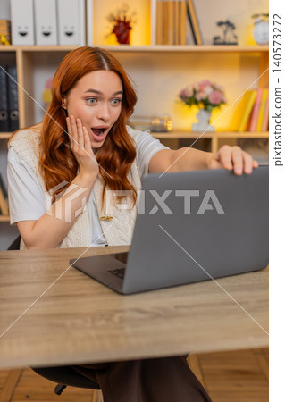 Young woman on home table seeing amazing laptop result with wow surprise and astonished joy at home Young woman on home table seeing amazing laptop result with wow surprise and astonished joy at home 140573272