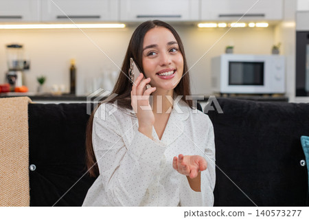 Young woman answers phone cheerful talk active friendly voice smiles laughs shares news lively chat 140573277