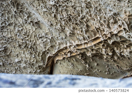 The rough rock surface texture of wave-eroded depressions, carved over many years. The rough rock surface texture of wave-eroded depressions, carved over many years. 140573824
