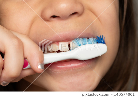 Child brushing teeth with toothbrush in bathroom mirror Child brushing teeth with toothbrush in bathroom mirror 140574001