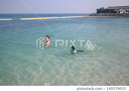 Asian woman and multiracial boy swimming in clear ocean water on Asian woman and multiracial boy swimming in clear ocean water on 140574033