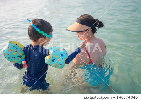 Mother and Son Enjoying a Day at the Beach, Playing in Shallow Water Mother and Son Enjoying a Day at the Beach, Playing in Shallow Water 140574040
