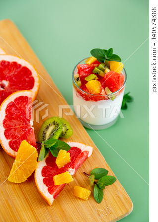 healthy breakfast yogurt with mixed fruits and mint on pastel background healthy breakfast yogurt with mixed fruits and mint on pastel background 140574388