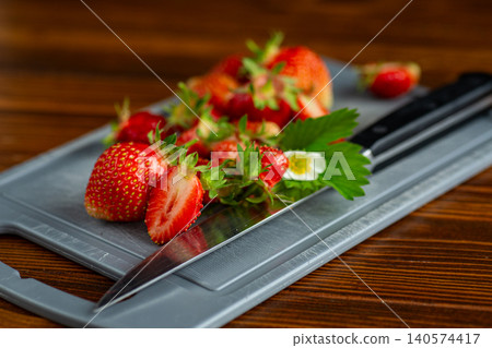Fresh ripe strawberries on cutting board in kitchen Fresh ripe strawberries on cutting board in kitchen 140574417