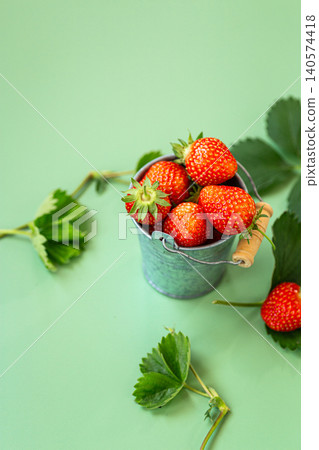 Ripe garden strawberries with leaves on pastel green Ripe garden strawberries with leaves on pastel green 140574418