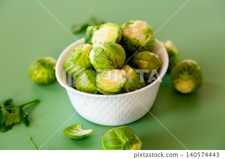 Healthy green Brussels sprouts with parsley on a green background Healthy green Brussels sprouts with parsley on a green background 140574443