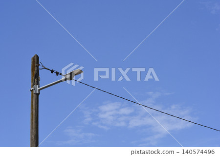 Modern LED Street Light on Wooden Pole Against Blue Sky Modern LED Street Light on Wooden Pole Against Blue Sky 140574496
