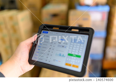 Hands operating an order terminal in a warehouse 140574600