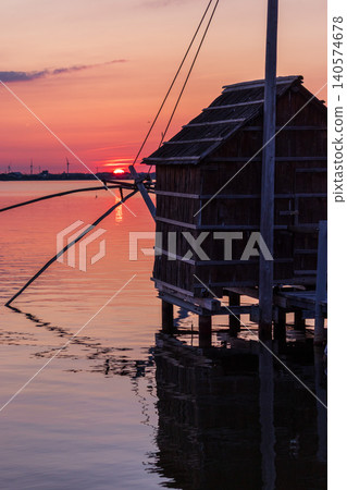 夕陽西下，多哥湖籠罩在一片絢麗的色彩中，呈現出寧靜的傍晚景色。 140574678