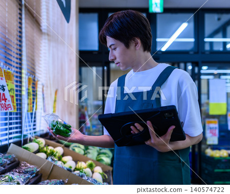 一位年輕的男店員正在用平板電腦查看庫存。 140574722