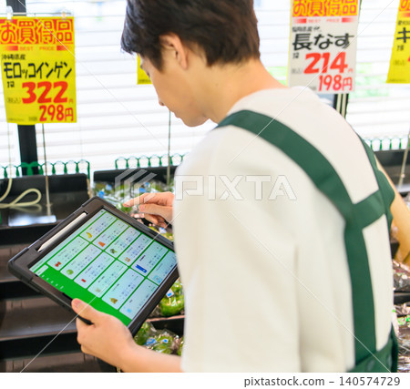 一名商店員工正在銷售區檢查終端機。 一名商店員工正在銷售區檢查終端機。 140574729