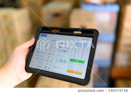Hands operating a tablet device in a warehouse Hands operating a tablet device in a warehouse 140574736