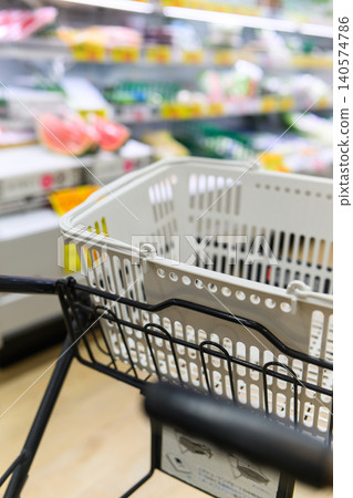A scene of someone carrying a shopping basket inside a store. 140574786