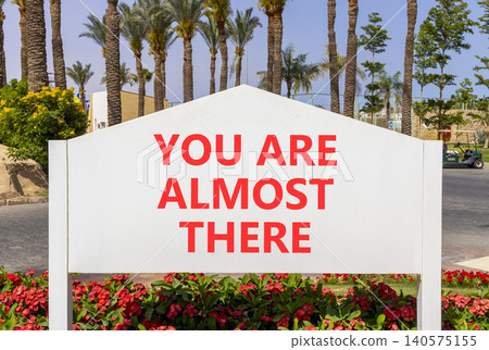 You are almost there symbol. Concept words You are almost there on beautiful white road sign. Beautiful palm trees background. Business You are almost there motivational support concept. Copy space You are almost there symbol. Concept words You are almost there on beautiful white road sign. Beautiful palm trees background. Business You are almost there motivational support concept. Copy space 140575155