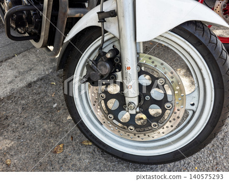 TAVERNES BLANQUES, SPAIN - JUNE 14, 2026. The vintage Suzuki motorcycle wheel is on display at a classic vehicle event. The close up shows the brake rotor, hydraulic caliper, and Bridgestone tire deta 140575293