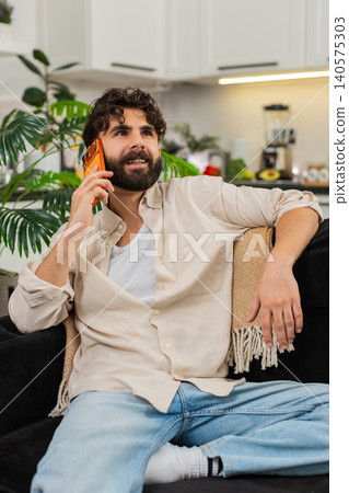 Indian man smartphone call talking with friend smiling relaxed friendly chat listening happy voice 140575303