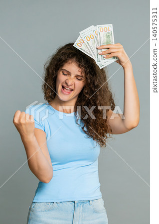 Woman hold dollar cash money smiling satisfied celebrating salary savings loan financial success joy Woman hold dollar cash money smiling satisfied celebrating salary savings loan financial success joy 140575311
