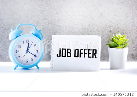 A notebook with a text about a job offer on a gray background 140575318