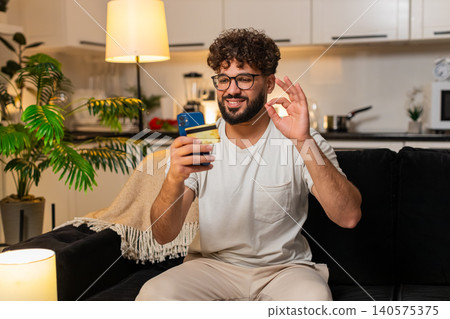 Arabian man confirms online payment with card on smartphone checks discount smiles stores e receipt Arabian man confirms online payment with card on smartphone checks discount smiles stores e receipt 140575375
