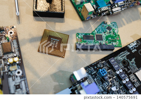 Computer parts and circuit boards on a work table with a central processor chip, screwdriver and tools, showing electronics repair, hardware upgrade and technology assembly. Computer parts and circuit boards on a work table with a central processor chip, screwdriver and tools, showing electronics repair, hardware upgrade and technology assembly. 140575691