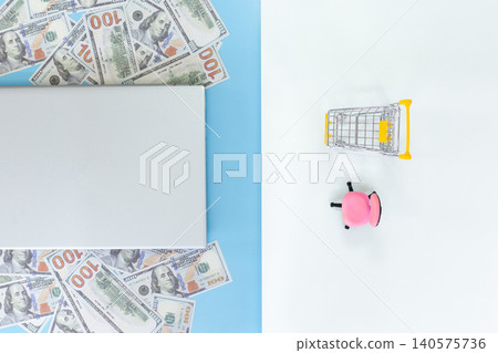 Bright cash scattered beside a tablet. Tiny shopping cart beside a pink piggy bank. Clean, minimal background. Ideal for finance, savings, or shopping concepts. Simple, cheerful, modern aesthetic Bright cash scattered beside a tablet. Tiny shopping cart beside a pink piggy bank. Clean, minimal background. Ideal for finance, savings, or shopping concepts. Simple, cheerful, modern aesthetic 140575736