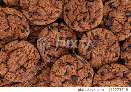 Close-Up Top View of Chocolate Chip Cookies Spilling from Small Yellow Shopping Cart Isolated on White Background 140575746