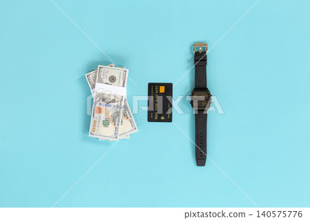 Money, card, and watch lie on bright blue background. No people, no animals, no plants present. Clean, minimalist setup suggests financial success or time management. Ideal for business, finance Money, card, and watch lie on bright blue background. No people, no animals, no plants present. Clean, minimalist setup suggests financial success or time management. Ideal for business, finance 140575776