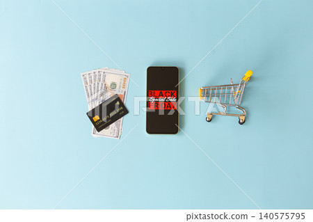 Minimalist shopping scene on soft blue background. Mobile phone shows Special Sale Friday in bold red text. Credit card rests beside device, symbolizing payment ease. Tiny shopping cart holds cash Minimalist shopping scene on soft blue background. Mobile phone shows Special Sale Friday in bold red text. Credit card rests beside device, symbolizing payment ease. Tiny shopping cart holds cash 140575795