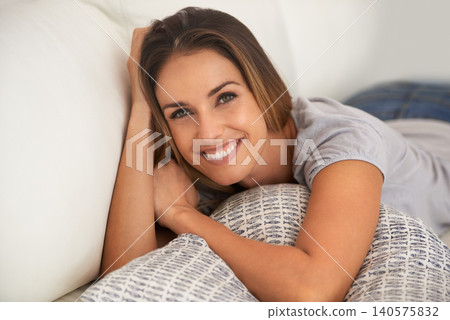 Woman, portrait and relax on couch in living room, calm and comfort with positive mood for leisure. Rest, lying down with pillow and smile for stress relief, break on day off or weekend at home Woman, portrait and relax on couch in living room, calm and comfort with positive mood for leisure. Rest, lying down with pillow and smile for stress relief, break on day off or weekend at home 140575832