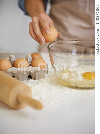 Baking, kitchen and person with eggs and flour for cake, bread and pastry preparation in home. Culinary, bakery and closeup of ingredients, wheat and utensils for recipe, dough and food on counter Baking, kitchen and person with eggs and flour for cake, bread and pastry preparation in home. Culinary, bakery and closeup of ingredients, wheat and utensils for recipe, dough and food on counter 140575866