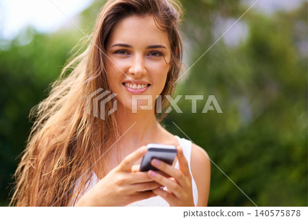 Cellphone, nature and portrait of woman in park networking on social media, app or internet. Serious, technology and young female person scroll on a phone for communication in outdoor field or garden 140575878