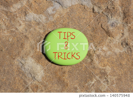 Tips and tricks words symbol. Concept words Tips and tricks on beautiful green stone. Beautiful brown stone background. Business tips and tricks motivational support concept. Copy space. 140575948