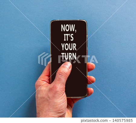 Now it's your turn symbol. Concept words Now it's your turn on beautiful phone screen. Beautiful blue background. Businessman hand. Business Now it's your turn motivational support concept. Copy space 140575985