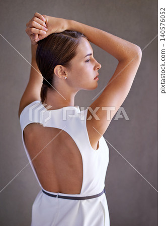 Elegant dress, fashion and woman in studio, cool or trendy style in gray background. Female model, confidence and proud with pride, standing and stylish or classy outfit or clothes with back view Elegant dress, fashion and woman in studio, cool or trendy style in gray background. Female model, confidence and proud with pride, standing and stylish or classy outfit or clothes with back view 140576052
