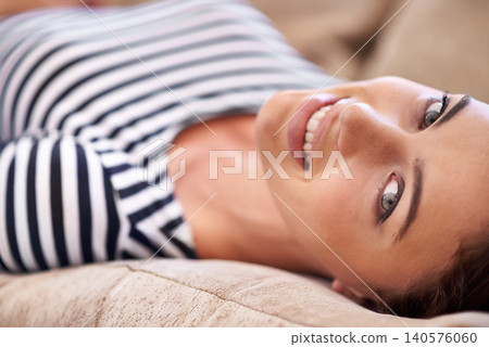 Woman, portrait and wellness to relax on couch, chill and smile while lazy or comfortable in home. Female person, happy and resting on sofa in living room, closeup and mindfulness or calm confidence 140576060