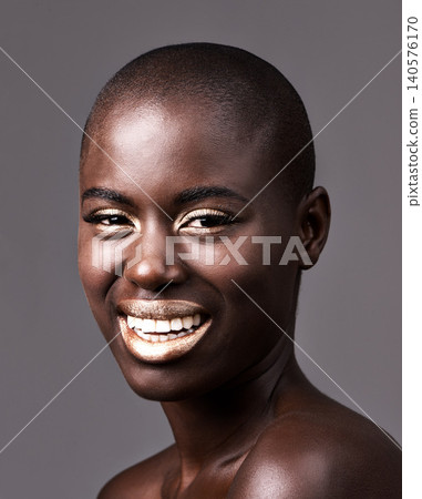 Portrait, skincare and makeup with bald black woman in studio on gray background for natural wellness. Face, beauty and smile with happy young model at spa for cosmetics, facial or dermatology 140576170