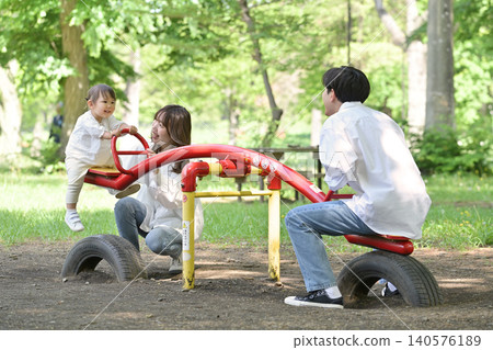 A family enjoying the seesaw in the park. A family enjoying the seesaw in the park. 140576189