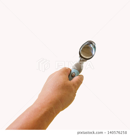 Ice-cream spoon in hand on background. Ice-cream spoon in hand on background. 140576258