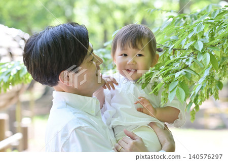 A young father holding his beloved daughter in his arms. A young father holding his beloved daughter in his arms. 140576297