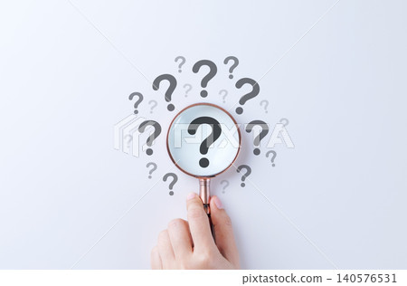 Question mark and root cause analysis concept. Hand holding magnifying glass over large question mark surrounded by smaller ones on white background, symbolizing analysis and problem-solving. solution 140576531