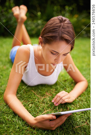 Park, grass and woman relax with tablet, backyard, outdoor and garden to chat or text on social media. Summer, nature and girl online with connection to internet to read romance ebook on site of app Park, grass and woman relax with tablet, backyard, outdoor and garden to chat or text on social media. Summer, nature and girl online with connection to internet to read romance ebook on site of app 140576656